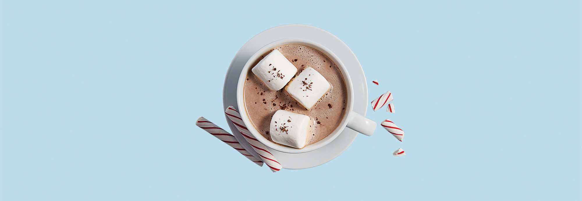 A hot chocolate garnished with marshmallows and candy canes